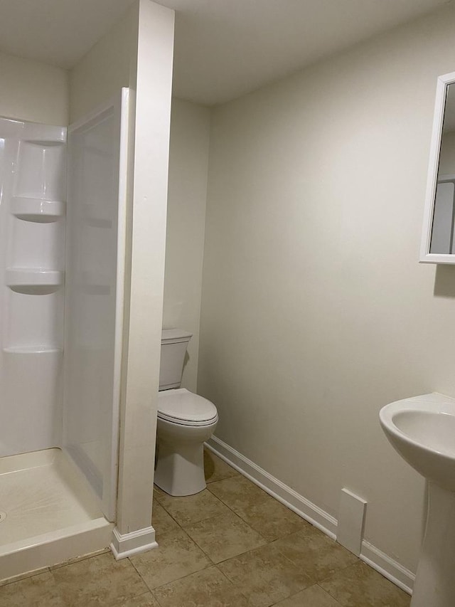 bathroom with tile patterned flooring, a shower, and toilet