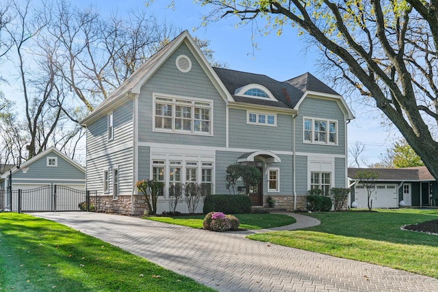 view of front of home featuring an outbuilding, a garage, and a front lawn