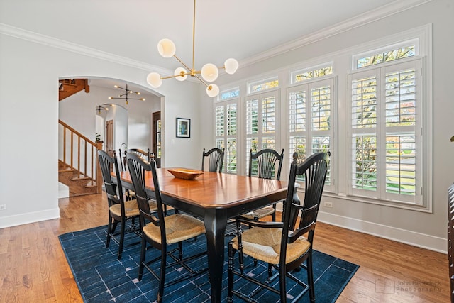 dining area featuring crown molding, a healthy amount of sunlight, and a notable chandelier