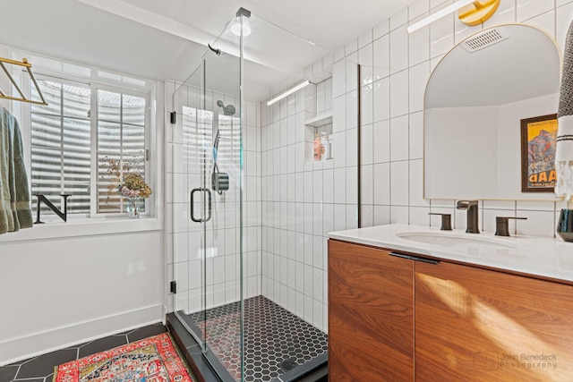 bathroom with tile patterned flooring, vanity, a shower with door, and tile walls