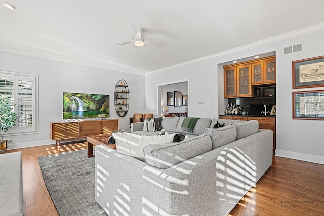 living room featuring crown molding, dark hardwood / wood-style floors, and ceiling fan