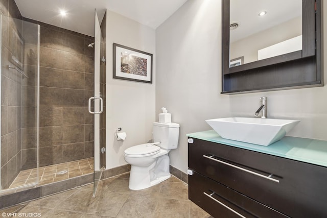 bathroom featuring vanity, a shower with shower door, and toilet