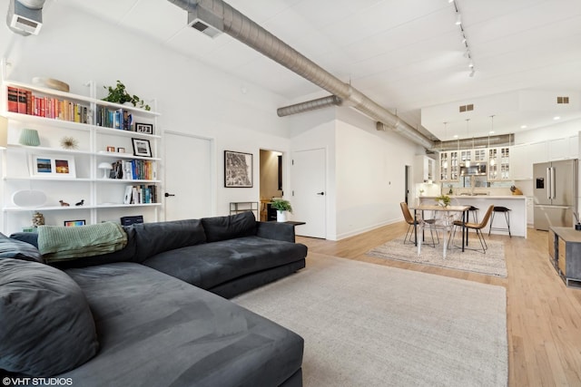 living room with track lighting and light wood-type flooring