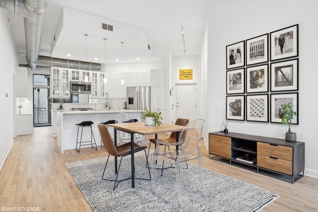 dining area with sink and light wood-type flooring