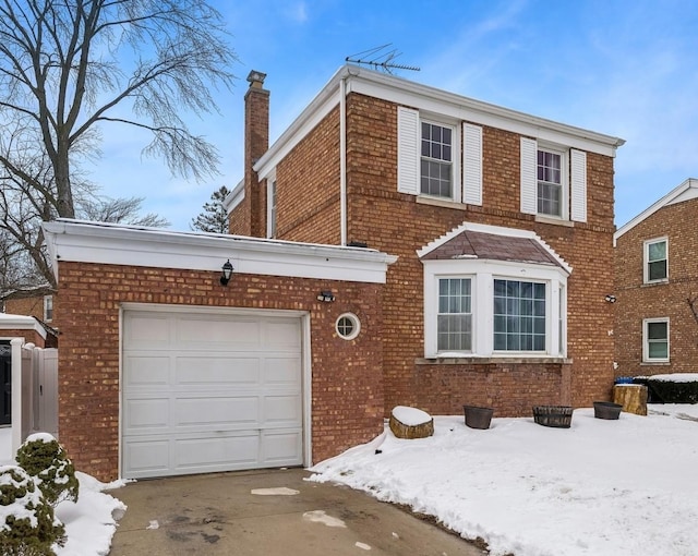 traditional-style house with driveway, brick siding, a chimney, and an attached garage