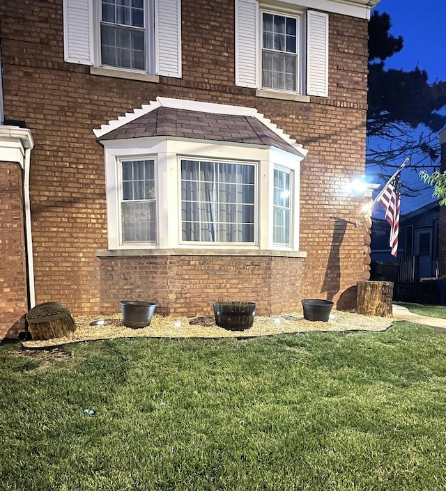 view of property exterior featuring a yard and brick siding