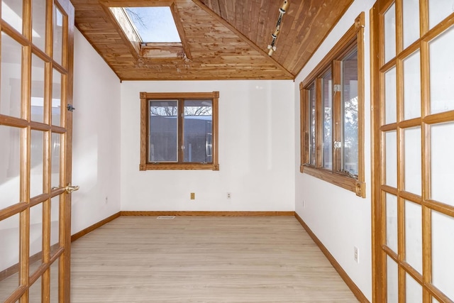 spare room with light wood-type flooring, wooden ceiling, and vaulted ceiling with skylight