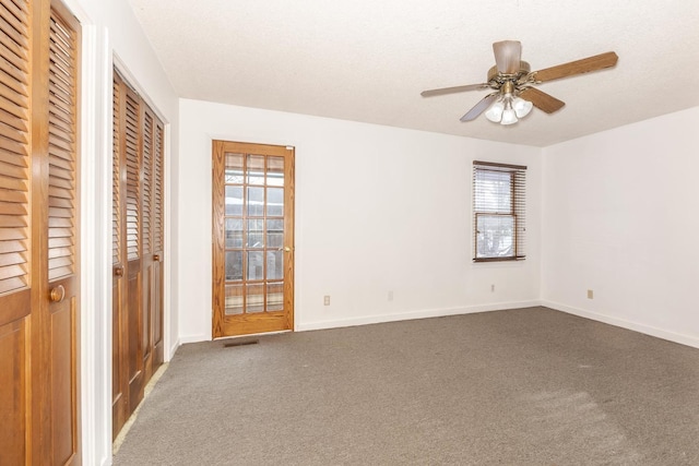 unfurnished room with carpet, ceiling fan, and a textured ceiling