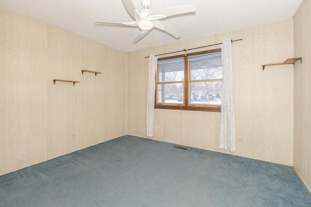 unfurnished room featuring dark carpet, ceiling fan, and a textured ceiling