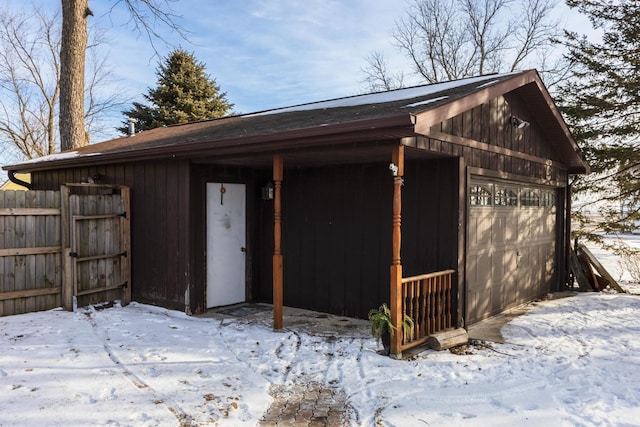 snow covered structure featuring a garage