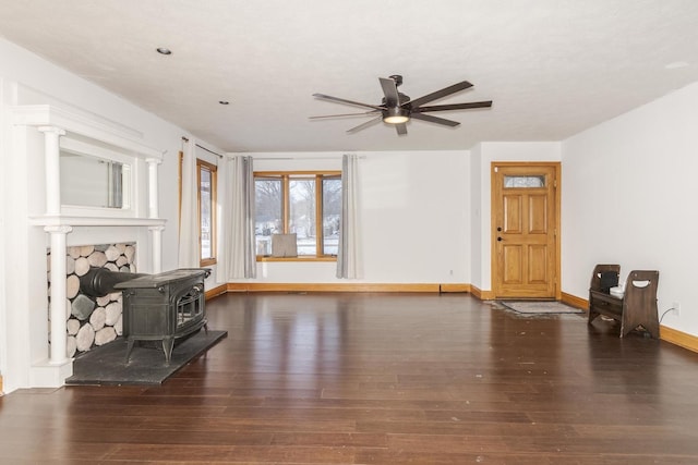 living room with a wood stove, dark hardwood / wood-style floors, and ceiling fan