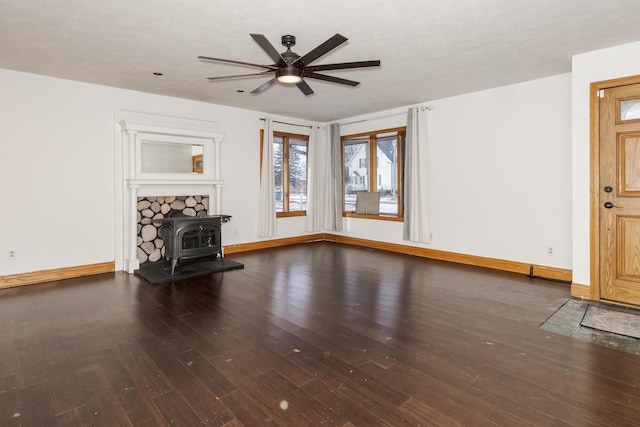 unfurnished living room featuring a wood stove, hardwood / wood-style flooring, and ceiling fan