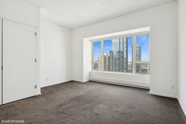 spare room featuring dark colored carpet