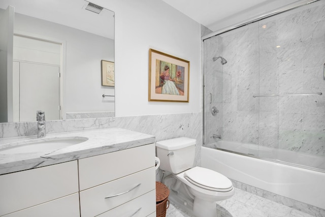 full bathroom with vanity, toilet, shower / bath combination with glass door, and tile walls