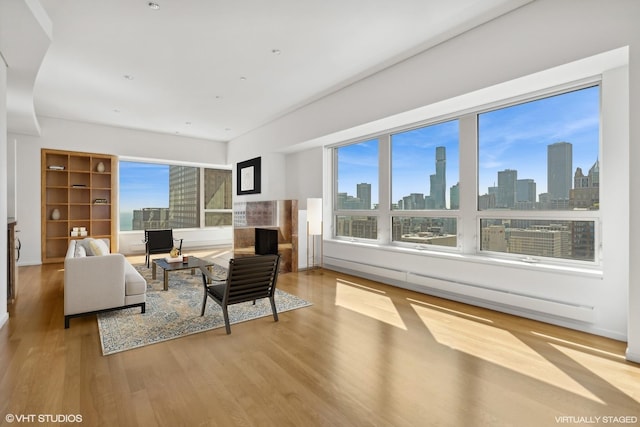 living room featuring plenty of natural light, a high end fireplace, and light hardwood / wood-style floors