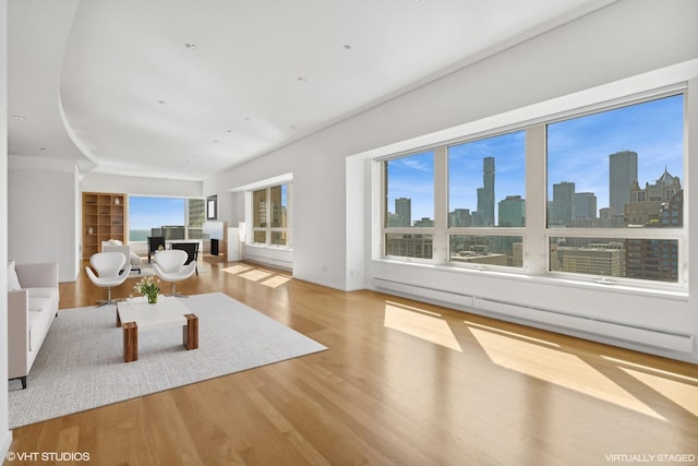 unfurnished living room featuring light wood-type flooring and baseboard heating