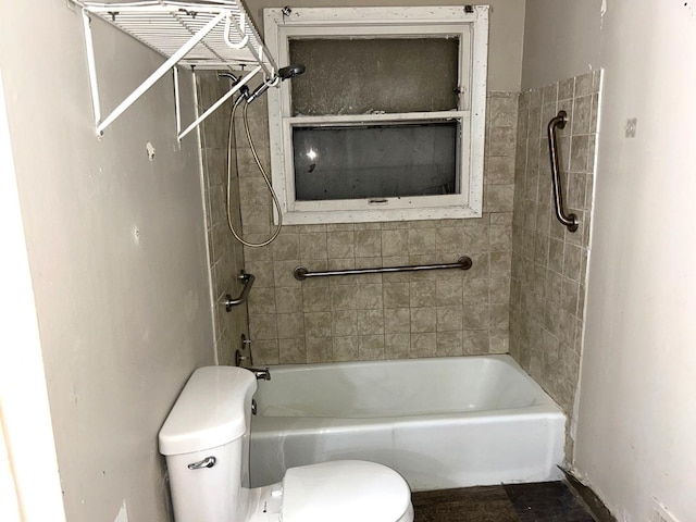 bathroom featuring tiled shower / bath and toilet