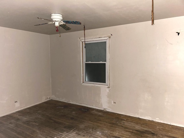 spare room featuring dark wood-type flooring and ceiling fan