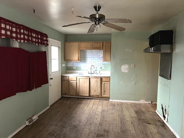 kitchen with ceiling fan, sink, hardwood / wood-style floors, and backsplash