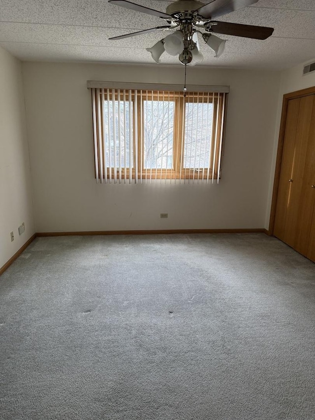 spare room featuring ceiling fan, carpet floors, and a textured ceiling