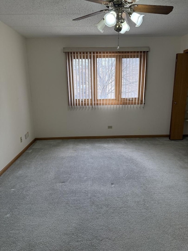 carpeted spare room featuring ceiling fan, a wealth of natural light, and a textured ceiling