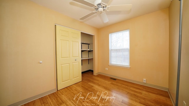 unfurnished bedroom featuring ceiling fan, light wood-type flooring, and a closet