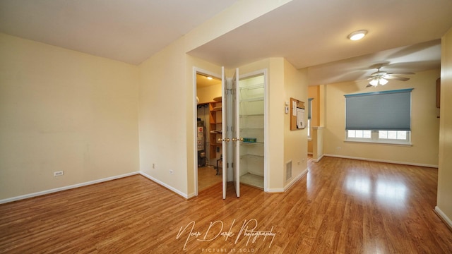 empty room with ceiling fan and wood-type flooring