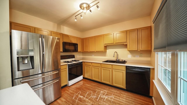 kitchen featuring sink, light hardwood / wood-style flooring, light brown cabinets, and black appliances