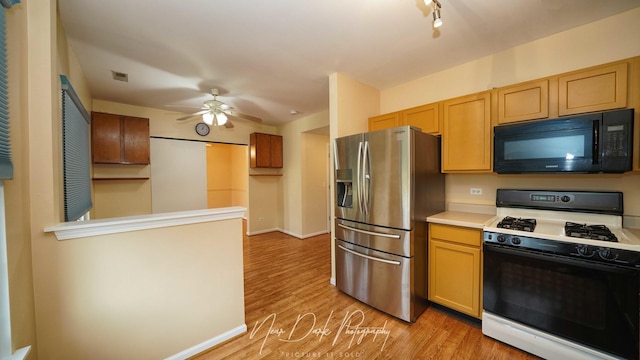 kitchen featuring stainless steel fridge with ice dispenser, gas range, light hardwood / wood-style floors, and ceiling fan