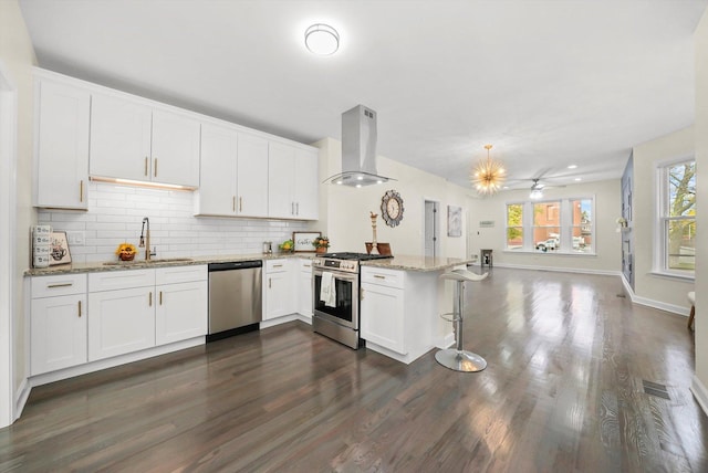 kitchen featuring white cabinetry, stainless steel appliances, kitchen peninsula, and extractor fan