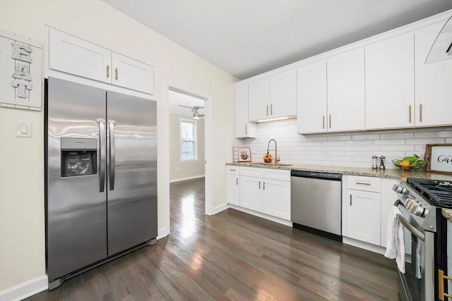 kitchen with sink, stainless steel appliances, light stone counters, white cabinets, and decorative backsplash