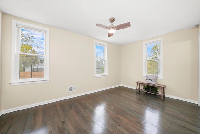 empty room with dark wood-type flooring and ceiling fan