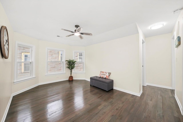 unfurnished room featuring dark wood-type flooring and ceiling fan