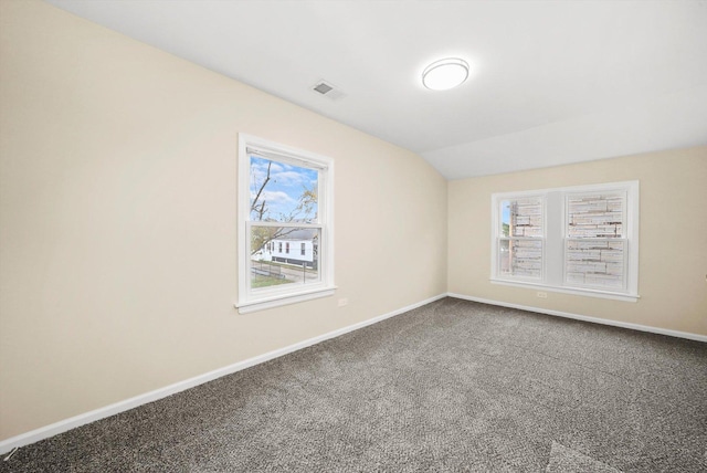 empty room with vaulted ceiling and carpet