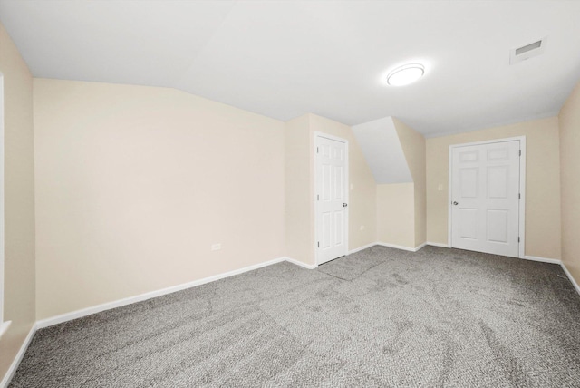 bonus room with lofted ceiling and light colored carpet