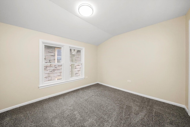 carpeted spare room with vaulted ceiling