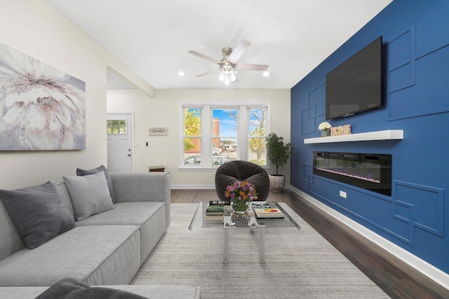 living room featuring dark wood-type flooring and ceiling fan