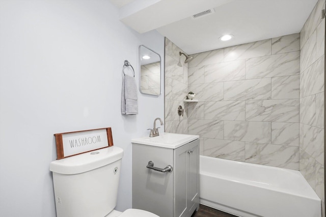 full bathroom with tiled shower / bath, vanity, and toilet