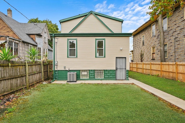 rear view of property featuring central AC unit and a lawn