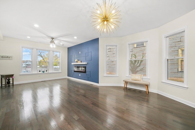 unfurnished living room featuring dark hardwood / wood-style floors and ceiling fan with notable chandelier