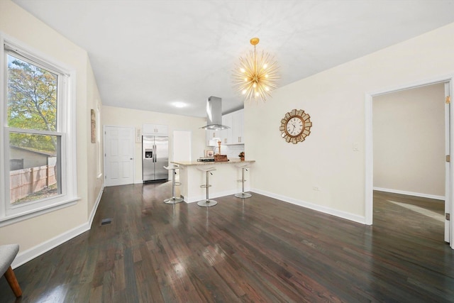 unfurnished living room with dark wood-type flooring and a notable chandelier