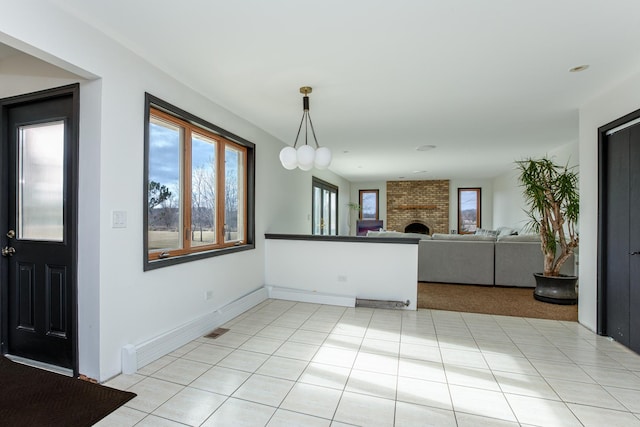 interior space with a brick fireplace and light tile patterned floors