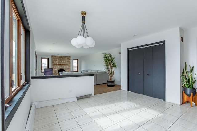 kitchen featuring pendant lighting, a fireplace, a chandelier, and baseboard heating