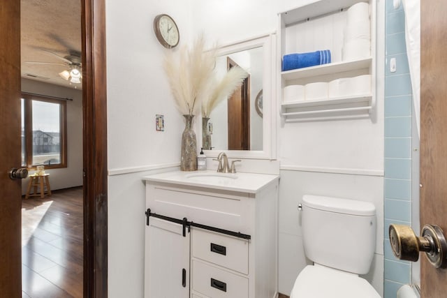 bathroom with vanity, wood-type flooring, ceiling fan, and toilet