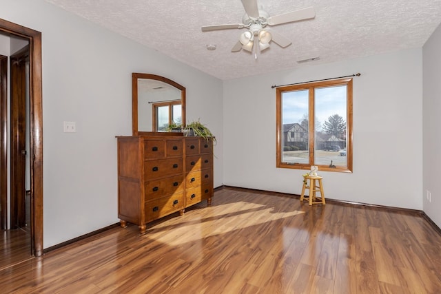 unfurnished room with hardwood / wood-style flooring, ceiling fan, and a textured ceiling