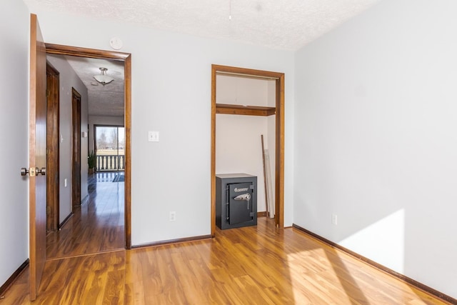 empty room with hardwood / wood-style floors and a textured ceiling