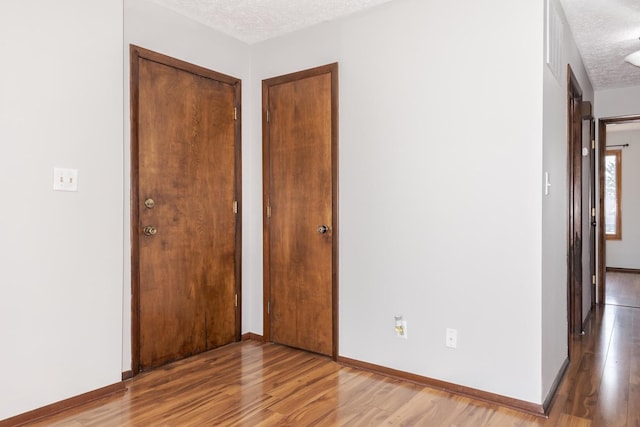 unfurnished room with wood-type flooring and a textured ceiling