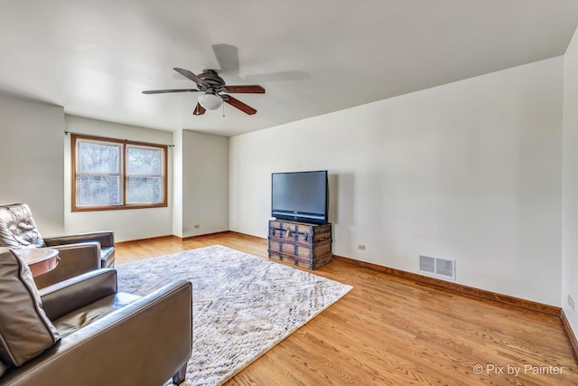 living room featuring light hardwood / wood-style flooring and ceiling fan