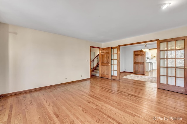 unfurnished room with french doors and light wood-type flooring