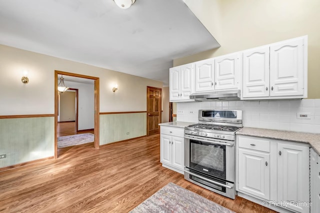 kitchen featuring white cabinetry, tasteful backsplash, light hardwood / wood-style flooring, and stainless steel gas range oven